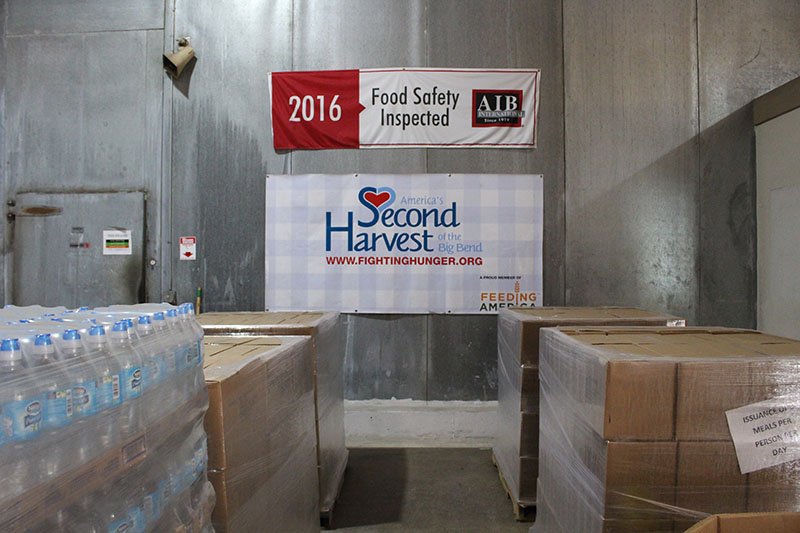 Second Harvest sign seen hung above stacks of boxes.